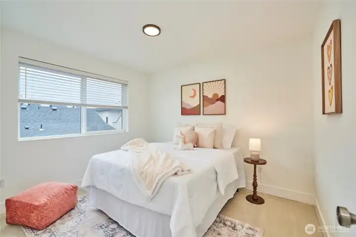 The top level of the home boasts 2 bedrooms. Here's the second bedroom staged as a "kids room". It's carpeted and offers ample closet space.