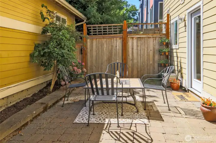 Private brick paver patio surrounded by gardens