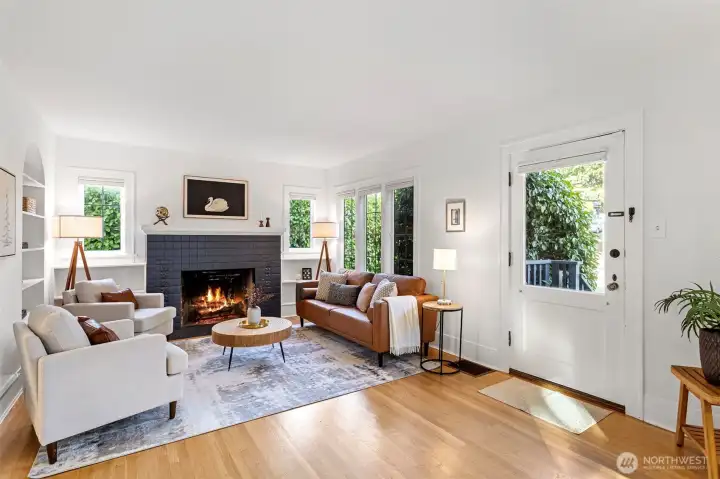 Show casing the glass paned front door, refinished hardwoods, fireplace, built-ins and tudor style leaded paned windows.