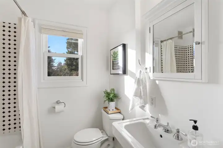 Main floor full bathroom with classic period tile and a pedestal sink