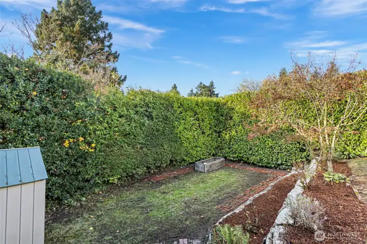 Freshly landscaped and full of character, this classic Tudor  shines with white stucco, black trim, and timeless curb appeal. A small back landing opens to the  tiered backyard—perfect for enjoying a morning coffee or tending the garden. With a dedicated  parking spot, new outdoor outlet for electric car charging, and a tidy garden shed, every detail  outside feels both functional and inviting.