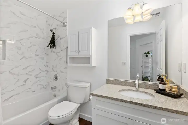 Guest bath with new tub, new tile surround  and updated cabinet fronts with newer hardware