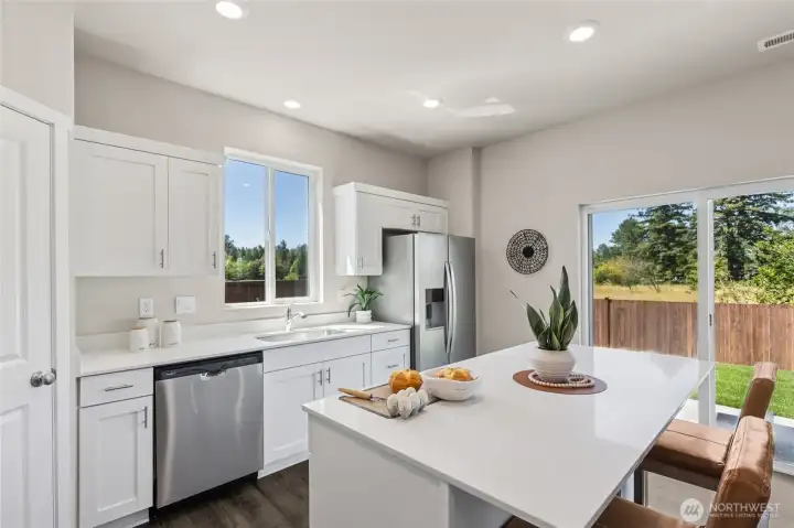 Quartz countertops and soft close doors on your cabinets in a beautiful kitchen space. Actual home is under construction and finishes, colors, and materials may vary. See site agent for details.