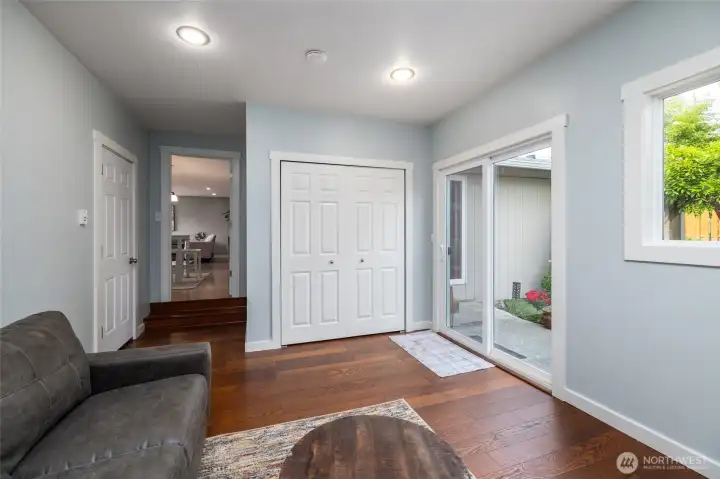 Family room, looking into the dining area. Closet doors open to laundry. Slider to back yard.