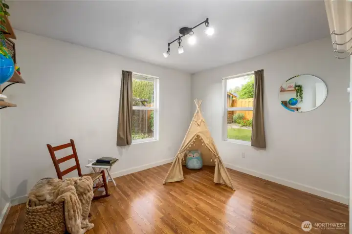 The third of three guest bedrooms, this corner room has two windows to the fenced back yard.