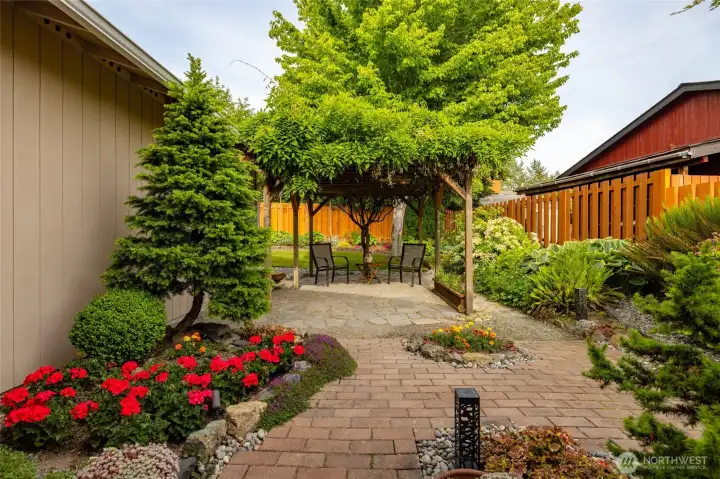 Another view of the patio and the wisteria covered pergola.  Gorgeously landscaped, this yard is lush and serene.