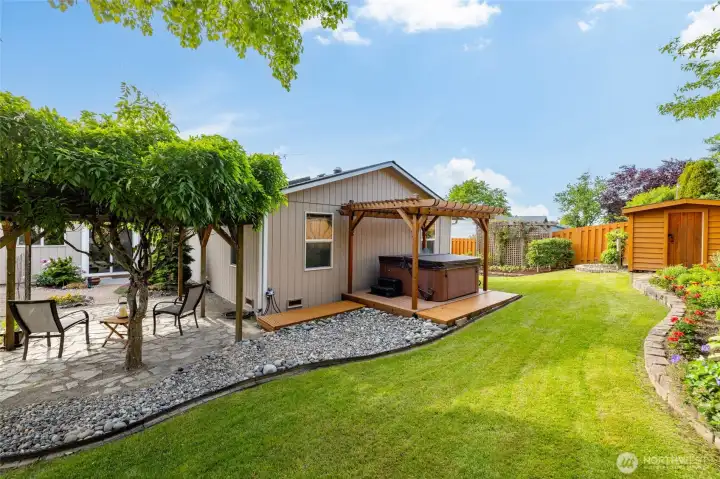 The hot tub deck sits at the back of the house.  Garden shed at right.