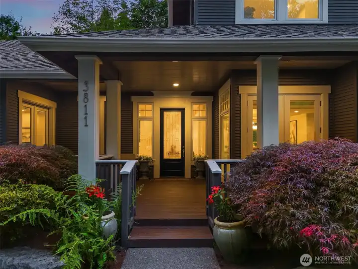 A grand covered porch and lush landscaping set a warm, welcoming tone before you ever step inside.
