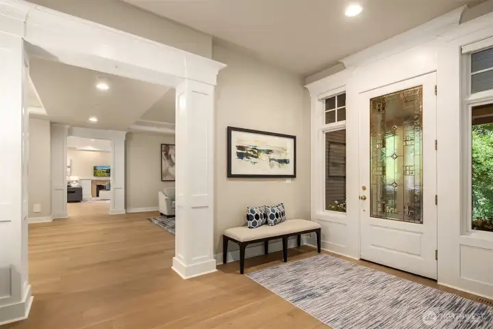 Wide doorways, rich hardwood floors, and beautiful millwork frame a seamless flow between the formal entry and the living spaces beyond.