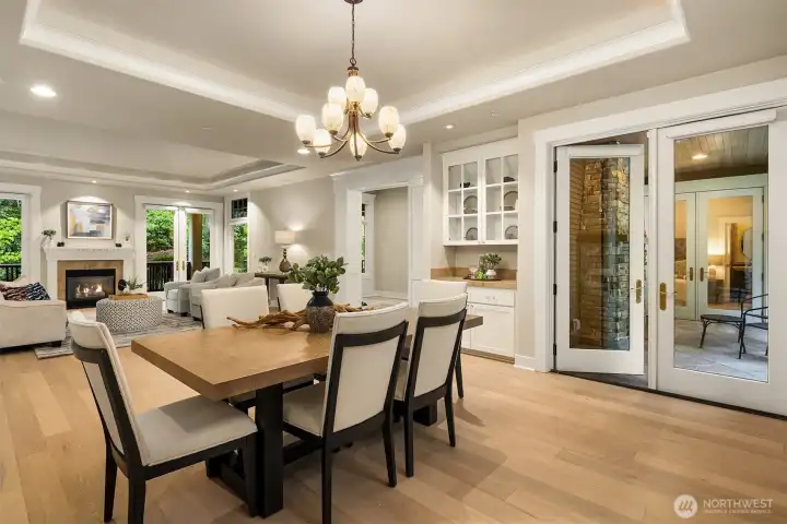 The formal dining room - appointed with a trayed ceiling, statement chandelier, and built-in butler's pantry - opens to the covered patio with gas fireplace and water feature, making entertaining feel effortless at any scale.