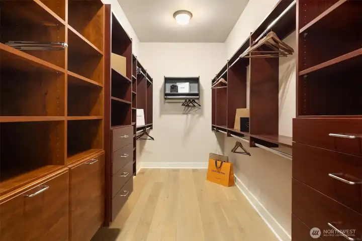 The professionally outfitted walk-in closet offers exceptional storage with warmth and craftsmanship to match.
