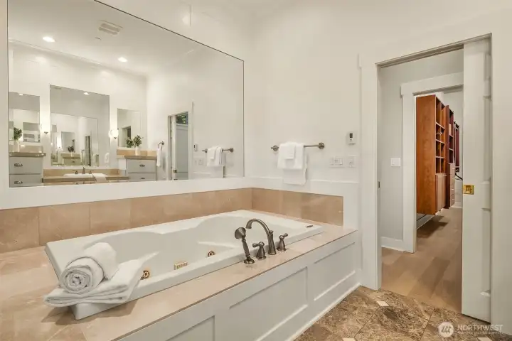 The primary bath features a jetted soaking tub, Emperador marble floors, radiant heat, and generous vanity space - a calm, unhurried space to start and end the day.