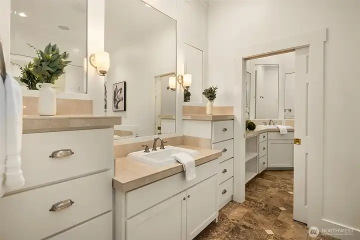 Double vanities with marble counters and abundant storage make this bath as functional as it is beautiful.
