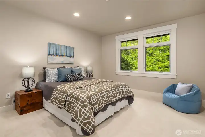 Spacious and serene, the second upper-level bedroom offers green outlooks, an outfitted walk-in closet, and room to truly settle in.