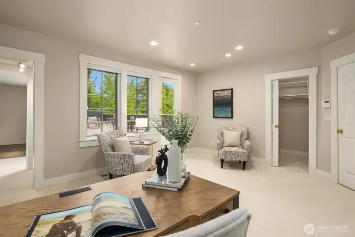A bright, flexible upper-level space -  perfectly suited as a study, media room, or fifth bedroom - with a  walk-in closet, deck access, and tree-lined views.