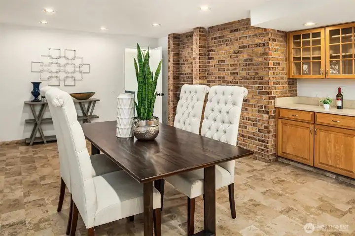 Dining area warmed by a charming brick-surround fireplace.