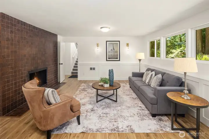 Floor-to-ceiling fireplace creates a dramatic focal point. Walls of windows fill the room with natural light.