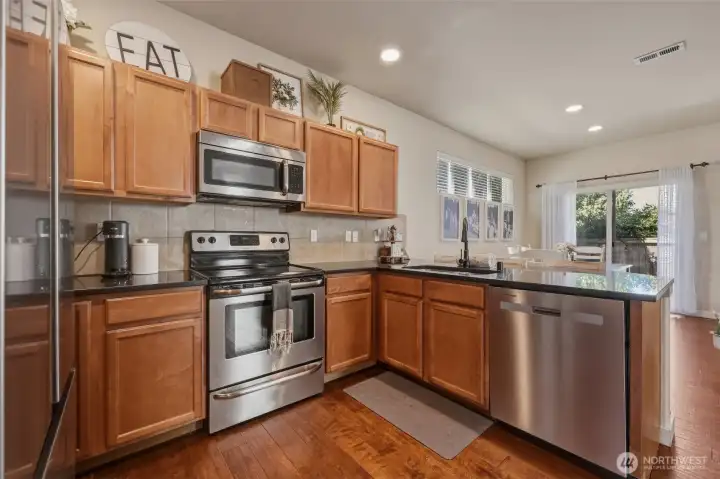 Gorgeous wood tones balance the stainless steel appliances and bring a natural beauty to this functional and lovely kitchen!
