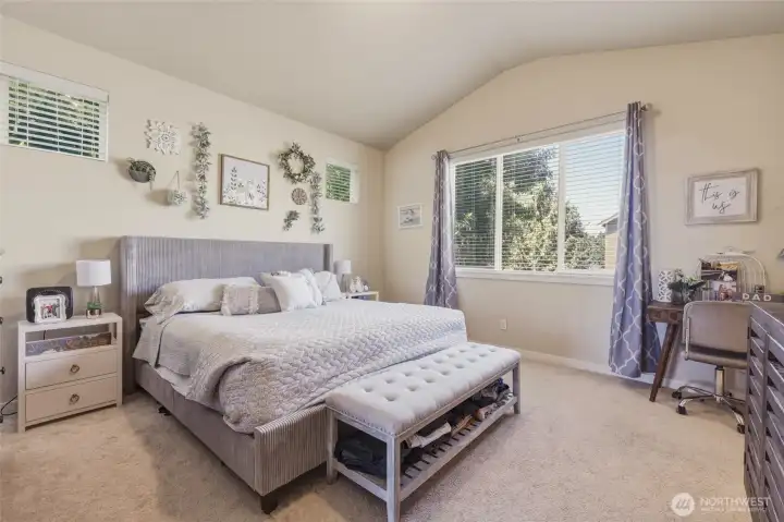 Primary suite has picture window looking out side yard (no nextdoor house!) and vaulted ceilings to emphasize the space and luxurious feeling.