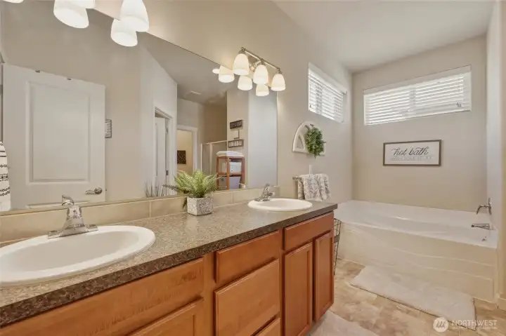 Double sinks in this long vanity with large mirror; the two high windows once again bring light without compromising privacy.