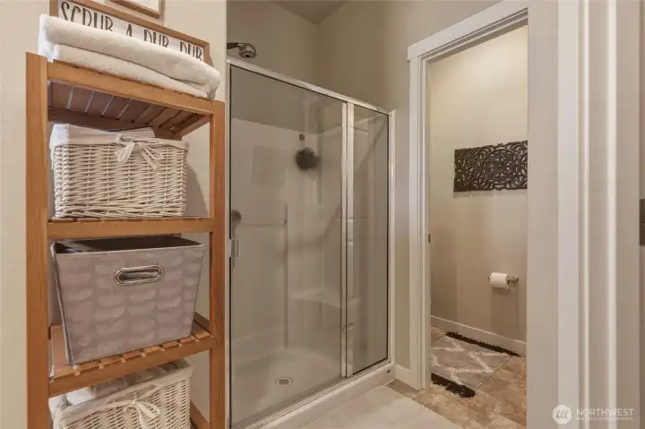 ... while the glass door shower is a calming way to start every day. Private commode room seen ahead.