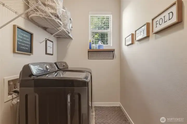 Situated convenientlly next to the primary suite, this laundry room has terrific space for storage (more than seen here), as well as another high window for natural light and ventilation.