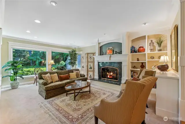 The living room has a gas fireplace with a beautiful mantle and custom bookcase.