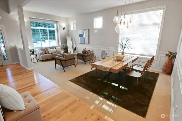 This photo shows the large windows, sunlight streaming in and gorgeous light colored wood floors.