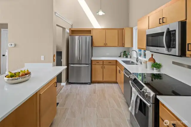 Chef-inspired kitchen with sleek quartz counters, maple cabinets, SS appliances and a lrg breakfast bar.