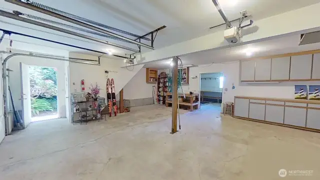 Large 2-car garage is extra deep, plus has separate shop space in the back. Stairs by the door lead up to the bonus room above.