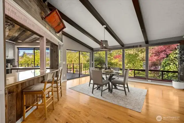 Large windows showcase the view and bathe the room in natural light. Breakfast nook and kitchen eating area. A second oversized glass sliding door on the main leads to the expansive deck.
