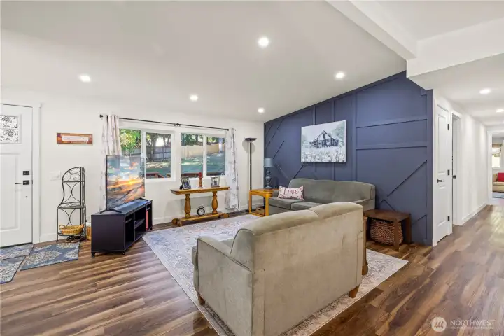 Vaulted Ceilings upon entrance of the home, living room space to entertain guests, with a accent wall.