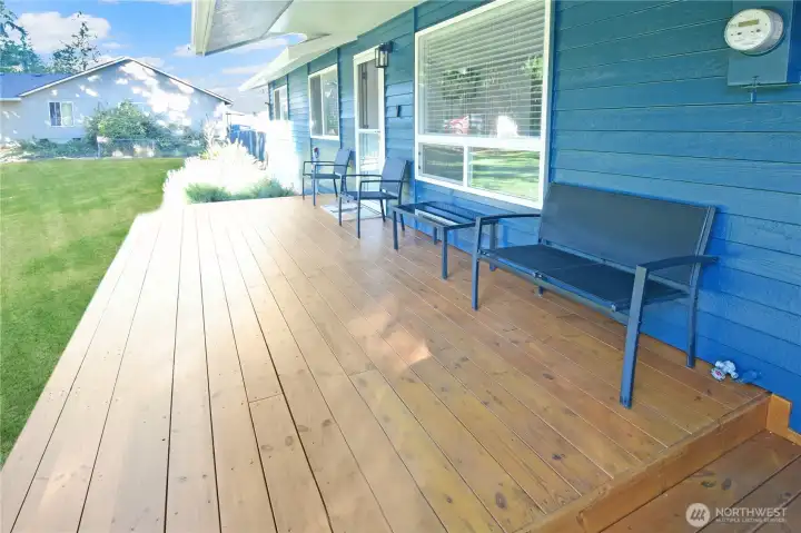 Close-up of the brand-new front deck with partial roof covering, offering sheltered outdoor seating and year-round enjoyment at this Bonney Lake home.