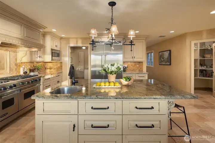 Huge island includes a prep sink and counter seating. Note the walk in pantry to the right in this photo.