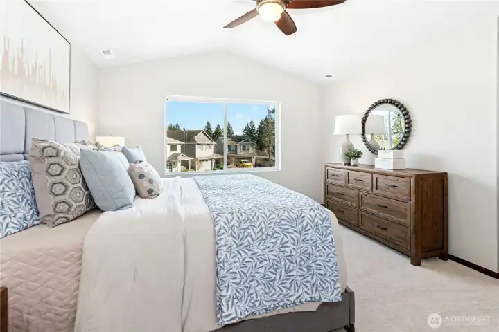 Primary bedroom with vaulted ceiling.