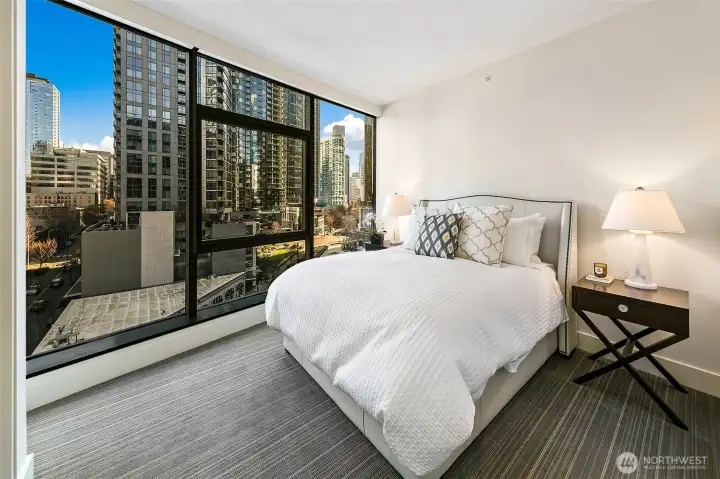 2nd bedroom with floor to ceiling window wall shows off the city skyline with concealed shades too.