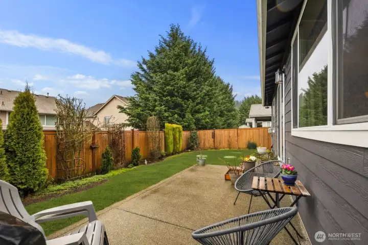 Alternate patio perspective showcasing the rear of the home, outdoor seating area, and sliding door access that connects indoor living to the backyard.