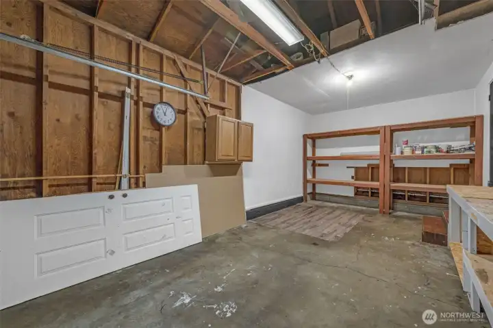 Nice size one car garage with extra storage space and shelving.