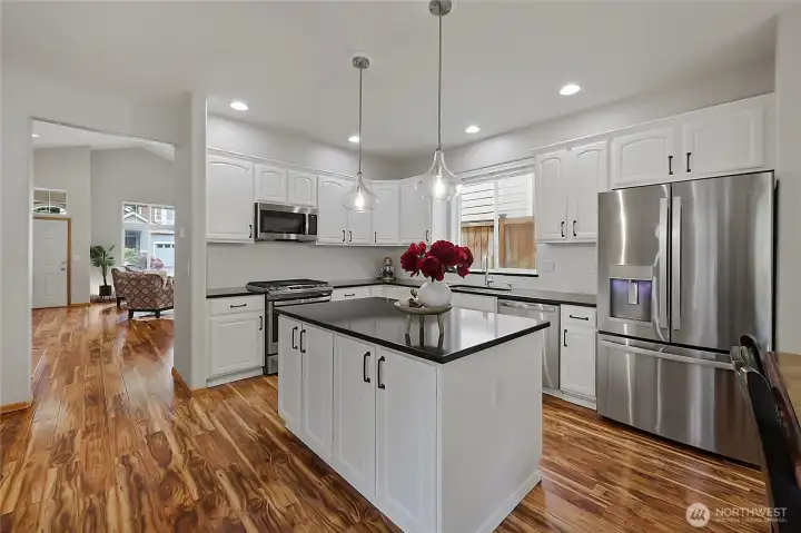 Stainless steel appliances, including a high-performance gas range and French door refrigerator, complement the elegant brushed-bronze hardware and designer pendant lighting. Stainless steel appliances, including a high-performance gas range and French door refrigerator, complement the elegant brushed-bronze hardware and designer pendant lighting.