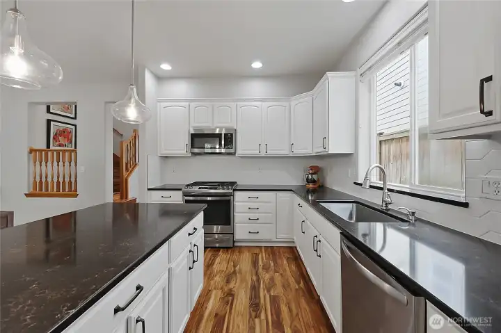 A masterpiece of design, this kitchen boasts crisp white cabinetry, sleek quartz countertops, and a modern hexagonal tile backsplash. The oversized center island offers extra prep space and a breakfast bar for casual dining. A masterpiece of design, this kitchen boasts crisp white cabinetry, sleek quartz countertops, and a modern hexagonal tile backsplash. The oversized center island offers extra prep space and a breakfast bar for casual dining.