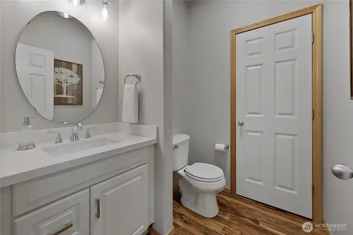 The stylish main-level half bath features a modern vanity and elegant fixtures. Notably, the oversized layout provides ample room to easily add a shower, offering the potential to convert this into a second full suite on the main floor. The stylish main-level half bath features a modern vanity and elegant fixtures. Notably, the oversized layout provides ample room to easily add a shower, offering the potential to convert this into a second full suite on the main floor.