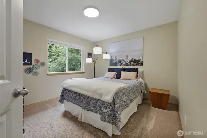 This bright and inviting guest bedroom features oversized windows that frame tranquil views of the surrounding greenery. With high-quality carpeting and neutral designer paint, it’s a versatile space perfect for a nursery, guest suite, or a quiet home office. This bright and inviting guest bedroom features oversized windows that frame tranquil views of the surrounding greenery. With high-quality carpeting and neutral designer paint, it’s a versatile space perfect for a nursery, guest suite, or a quiet home office.