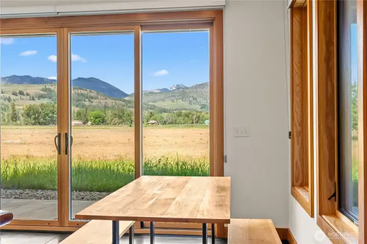 Quality craftsmanship is evident in the vertical grain fir trim, doors, and cabinetry, along with Andersen wood-wrapped windows and a freestanding propane stove.