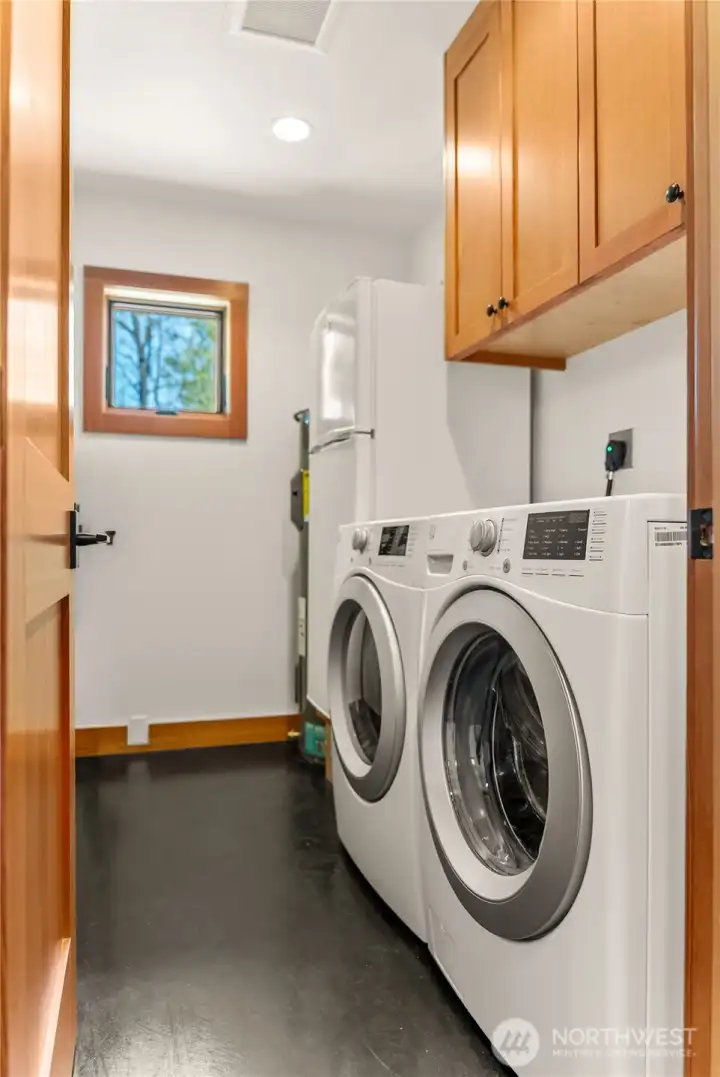 Laundry room with new 50gal hot water tank has remote control app, plus auto leak detection and shutoff. In line sediment filter for domestic water is also located in this spacious laundry room. The additional fridge in teh laundry room stays with the house.