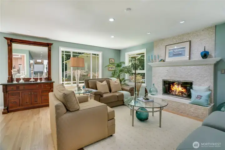 Airy living room anchored by a stone-faced fireplace and oversized windows with plantation shutters. Airy living room anchored by a stone-faced fireplace and oversized windows with plantation shutters.