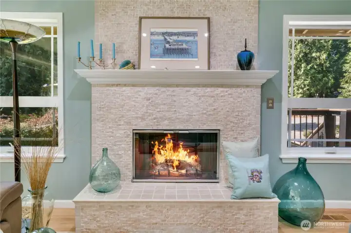 Glass-front fireplace wrapped in stone tile — the heart of the main floor. Glass-front fireplace wrapped in stone tile — the heart of the main floor.