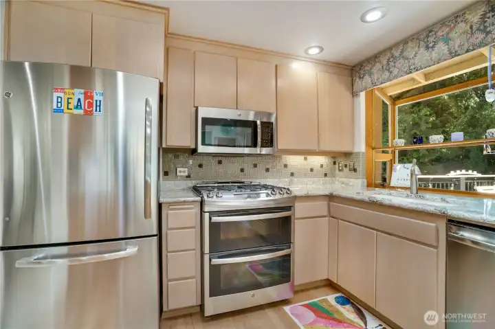 Stainless GE gas range with double oven under a bright skylight. Stainless GE gas range with double oven under a bright skylight.