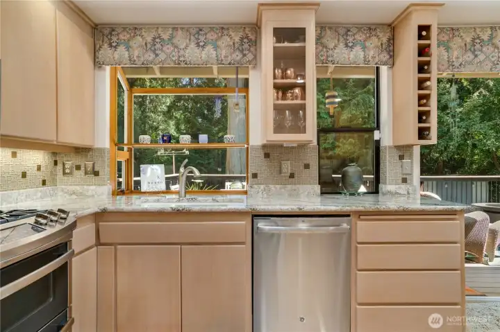 Garden window over the sink frames the evergreens. Garden window over the sink frames the evergreens.