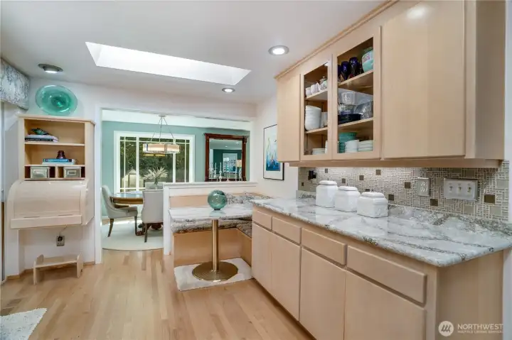 Glass-front display cabinets and serving counter connect kitchen to dining. Glass-front display cabinets and serving counter connect kitchen to dining.