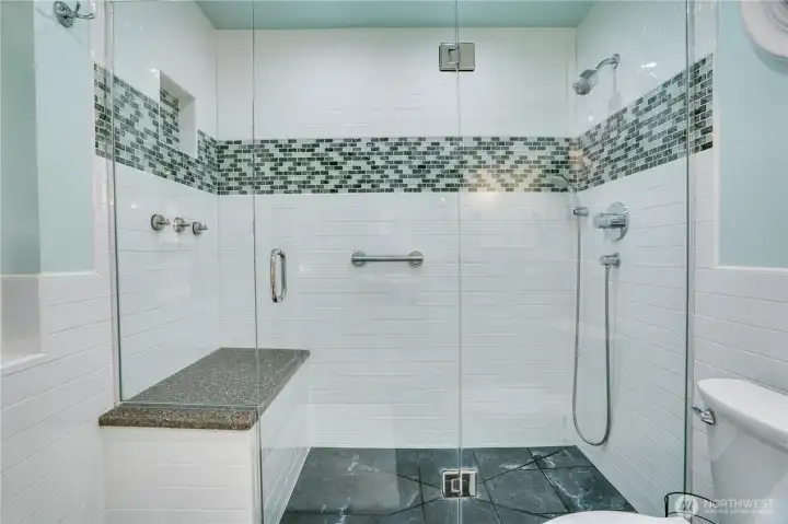 Remodeled primary bath: frameless glass, subway & mosaic tile, quartz bench. Remodeled primary bath: frameless glass, subway & mosaic tile, quartz bench.